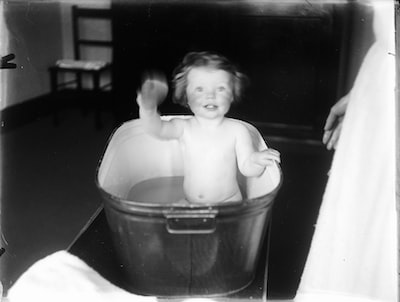 Old image of a waving child in a bathtub: socialhistoryarchive on Unsplash
